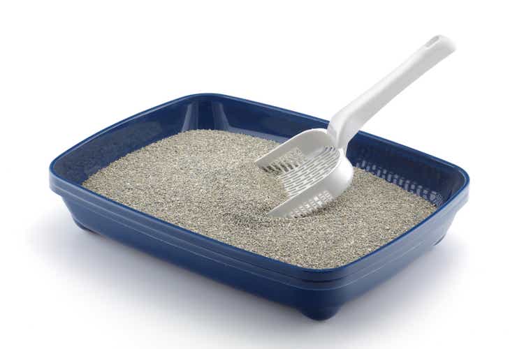 Blue cat litter tray isolated on white with grey litter and a scoop