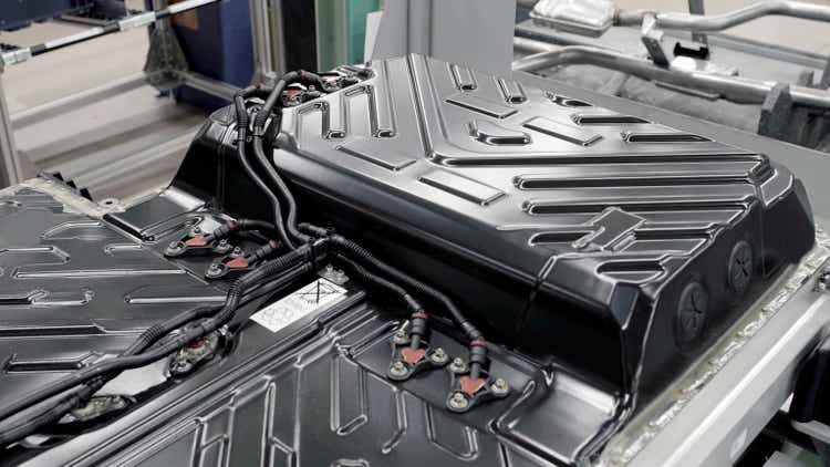 close-up of a lithium battery, for electric cars, on a table, with a black casing and on the production line. Interior of an electric car factory.