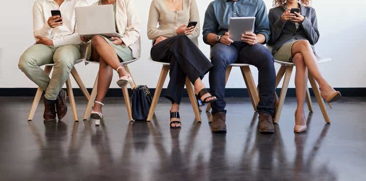 Shot of a group of businesspeople waiting in a line in a modern office