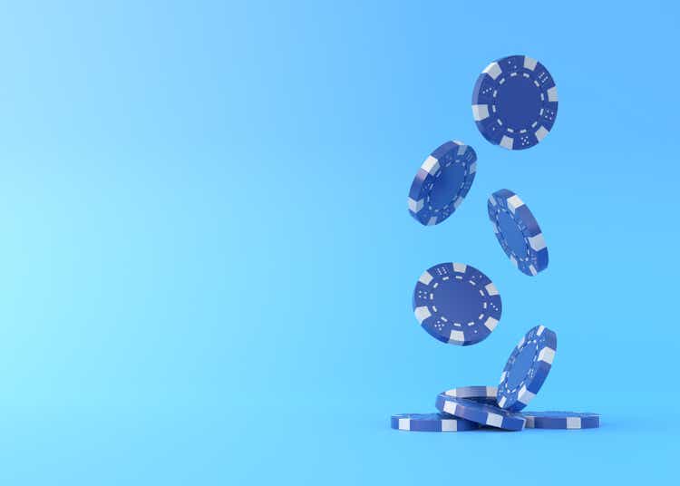 Lots of blue poker chips falling down on a blue background with copy space