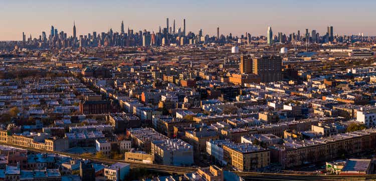 Manhattan Midtown Skyline includes the Empire State Building, Hudson Yards, and other iconic skyscrapers. View over the residential district of Bushwick, Brooklyn, at sunset. Extra-large, high-resolution stitched panorama.