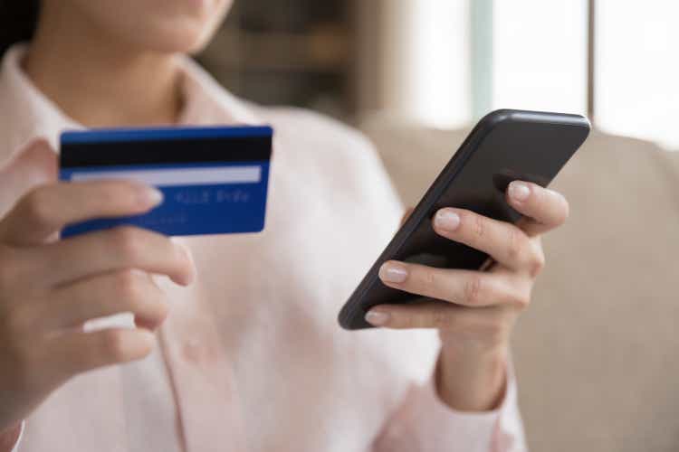 Close up happy young woman making payments online.