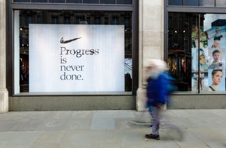 Exterior of Niketown sports store with people on city street in London, UK