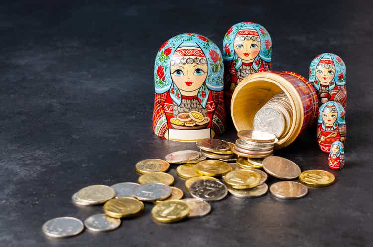 Traditional Russian toy matryoshka and money. Black concrete background.