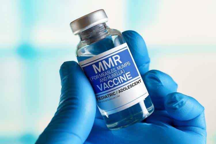 Doctor with vial of the doses vaccine for MMR Measless, Mumps and Rubella diseases. Medicine and health care concept