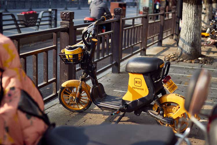 Meituan sharing electric bicycles parked in the parking area under a sunny day