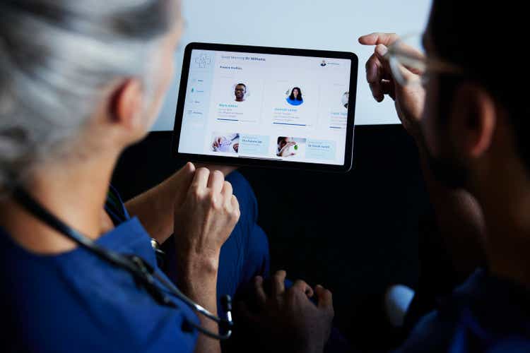 Two doctors looking at patient data on digital tablet