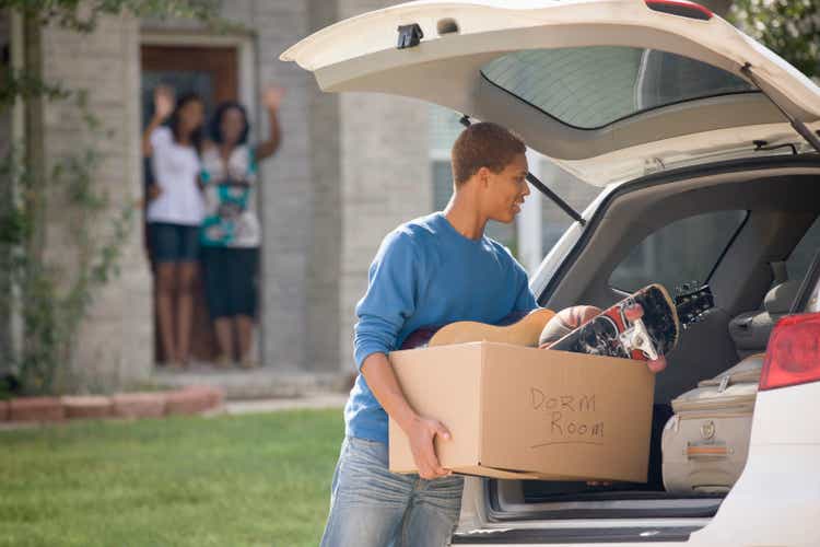 Mixed race teenager loading car for college