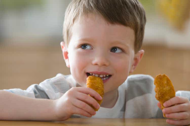 Caucasian boy eating chicken nuggets