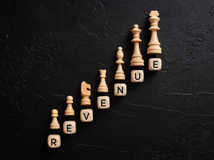 The word revenue on wooden cubes with chess pieces.