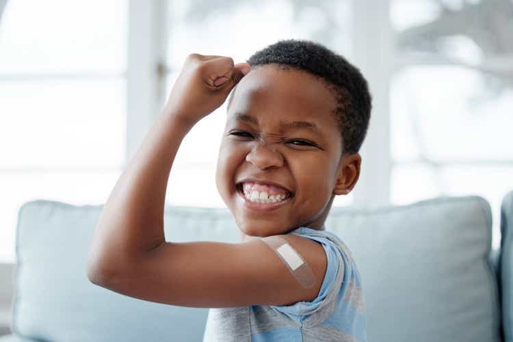 Portrait of a little boy with a plaster on his arm after an injection