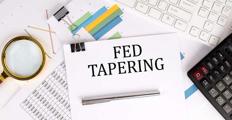 FED TAPERING text on white paper on the light background with charts paper