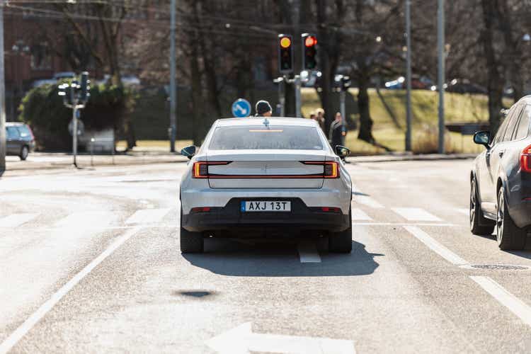 White Polestar 2 electric car waiting for green light..