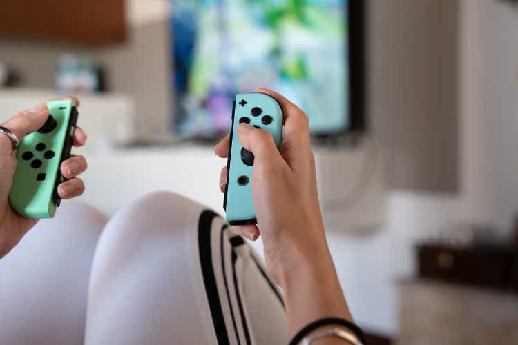 junges Mädchen spielt zu Hause mit Nintendo Switch Special Edition - selektiver Fokus