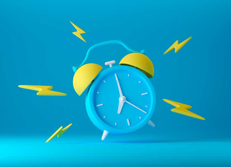 Blue vintage ringing alarm clock with bright yellow lightings