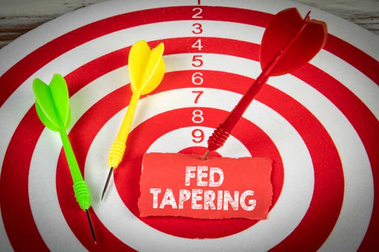 FED TAPERING. Piece of red paper and darts on the target