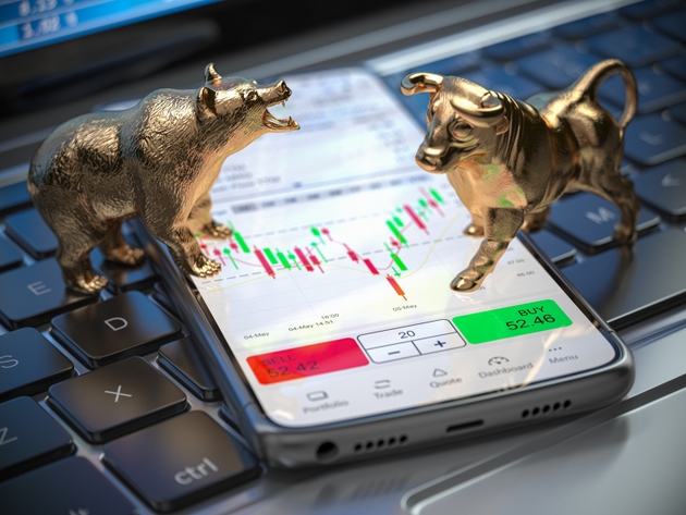 Golden bull and bear as symbols of stock market on a smartphone with stock market data application on the screen.