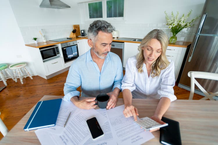 Mature couple doing paperwork and paying bills at home