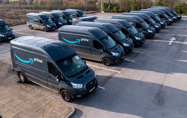 A row of new Ford E-Transit vans with Amazon Prime livery at a fulfilment centre