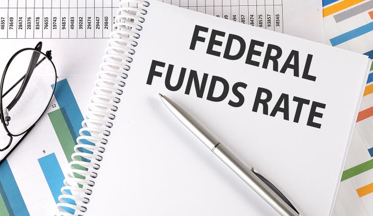 FEDERAL FUNDS RATE text , pen and glasses on the chart