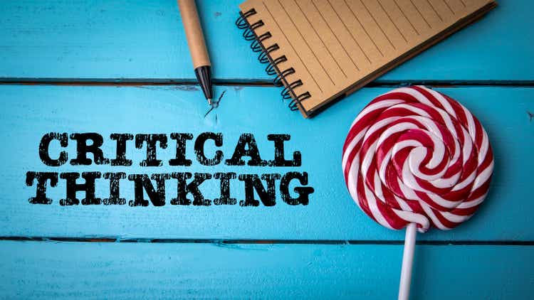 Critical thinking. Colored candy and office supplies on a wooden background