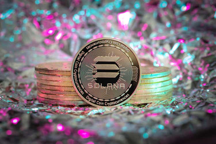 Solana SOL cryptocurrency physical coin, abstract background.