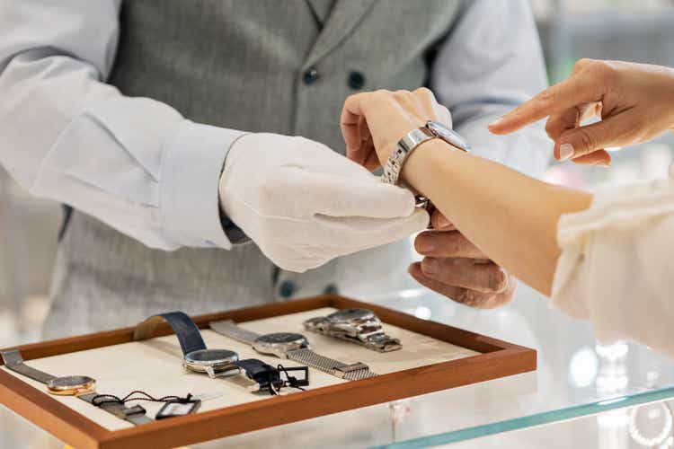 Young unrecognizable woman trying a wristwatch in jewelry store