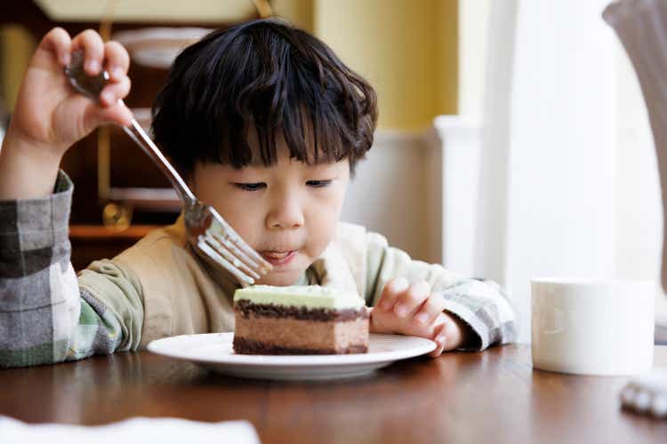 A little boy eating cake in the kitchen