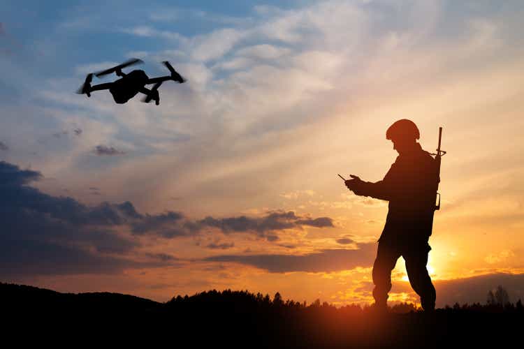 Silhouette of soldier are using drone and laptop computer for scouting during military operation.