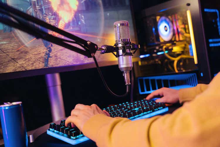 Closeup of gamer"s hands on professional gaming keyboard and microphone for live streaming