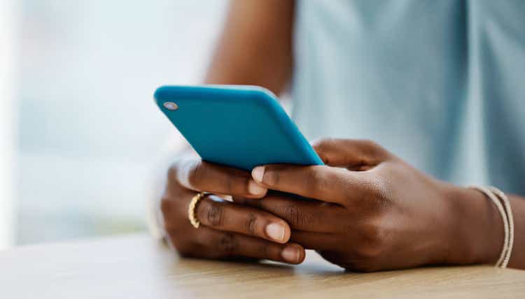 Mujer africana usando un teléfono celular en una oficina sola