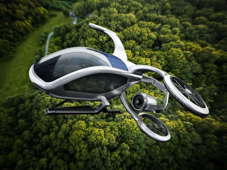 Conceptual eVTOL (electric vertical take-off and landing) aircraft flying against a dense forest background