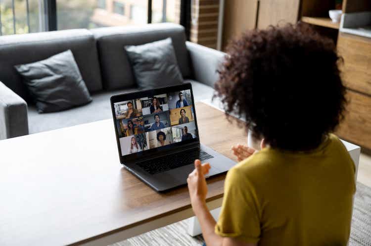 Woman talking to some colleagues in an online business meeting while working at home