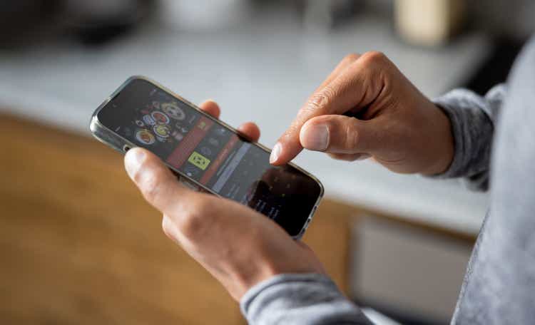 Close-up on a man betting online on a sports app in his cell phone