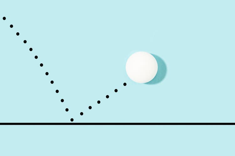 White ping pong ball bouncing on a light blue background