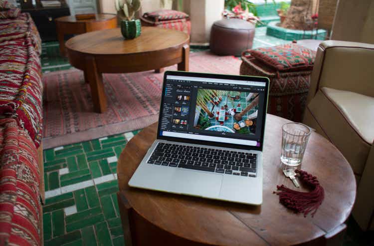 Laptop on a wooden table in lounge area of Moroccan riad