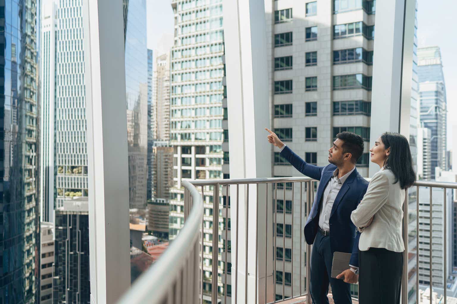 Man looking through window at cityscape stock photo - OFFSET