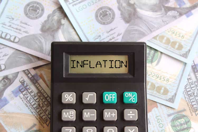 Close up image of banknotes and calculator with text INFLATION.