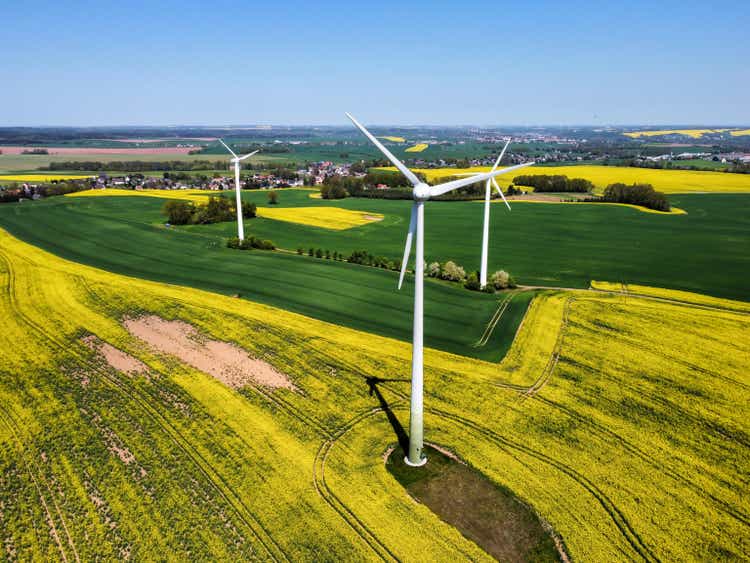 Wind turbine in a blooming rapeseed field from above
