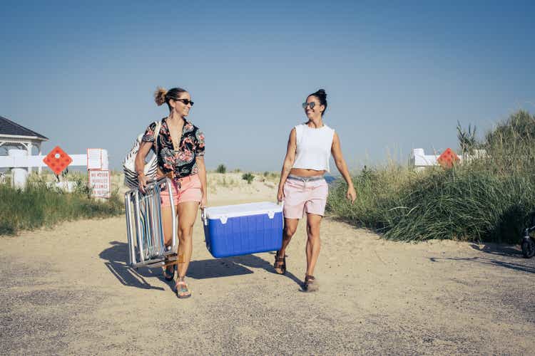 Women carrying cooler at beach