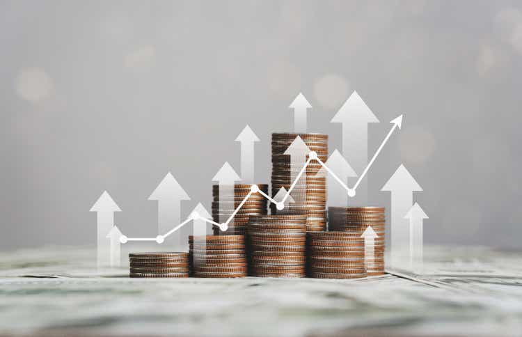 A stack of silver coins with a trading chart in financial concepts and financial investment business growth stocks