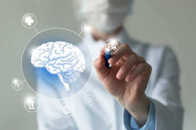 Unrecognizable female doctor holding graphic virtual visualization model of Brain organ in hands. Multiple virtual medical icons.