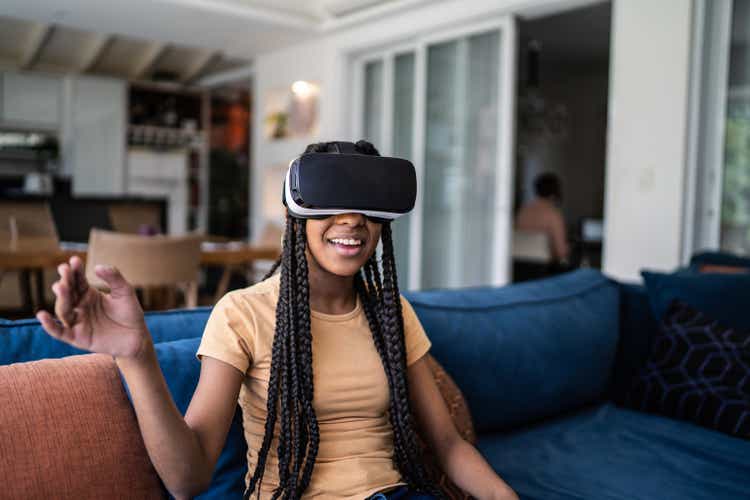 Teenage girl playing using VR glasses at home