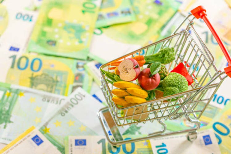 Food basket in Europe.food crisis. Rising food prices in the European Union.Decorative supermarket trolley with groceries on euro banknotes background.Food basket