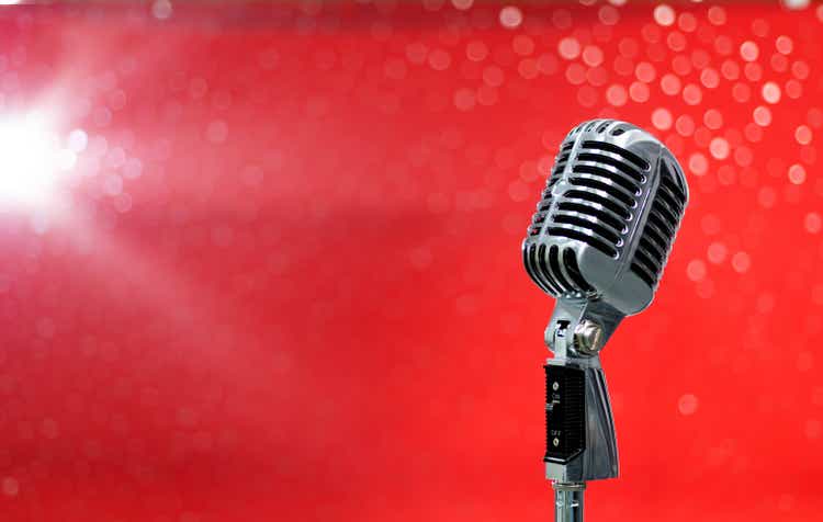 Retro microphone on shiny red background