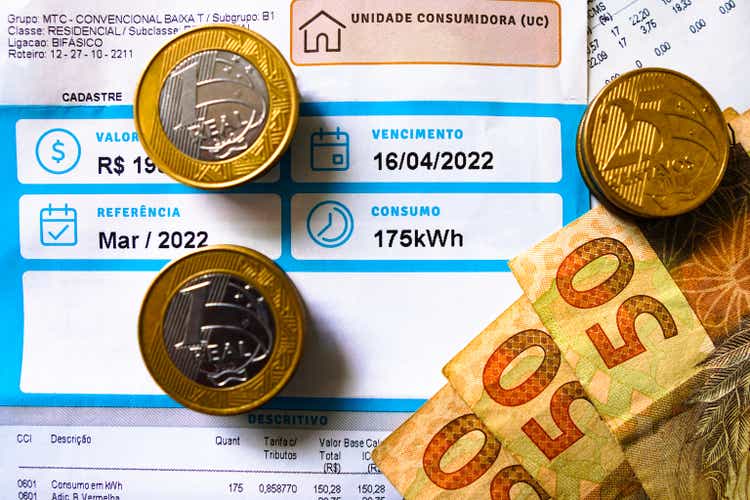May 19, 2022, Brazil. An electricity bill (electricity), indicating the monthly consumption of 175 kilowatt-hours (kWh), with banknotes and coins of the Brazilian Real.