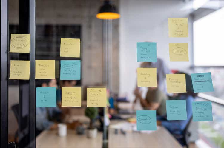 Business strategy written on a board using post its
