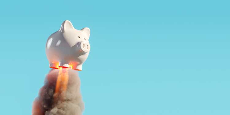 Piggy bank rocket launcher with smoke trail on blue background. Savings growth concept.