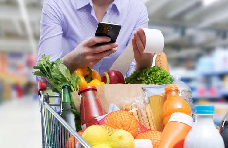 Woman checking grocery receipt