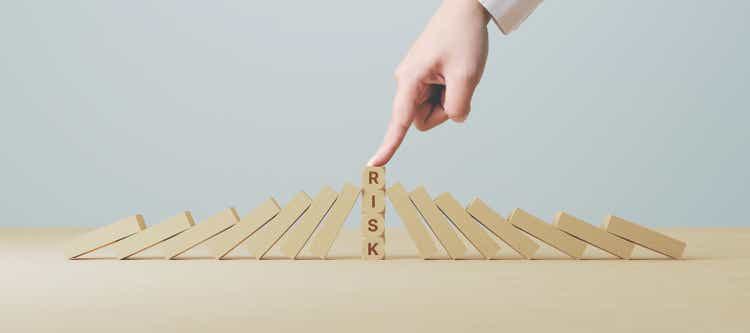 Risk management concept. Hand stop wooden block domino effect for business